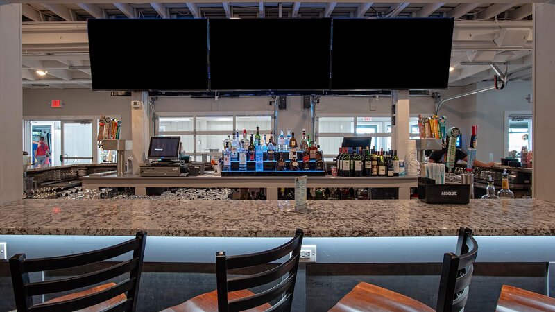 Inside bar with view of three televisions above bar