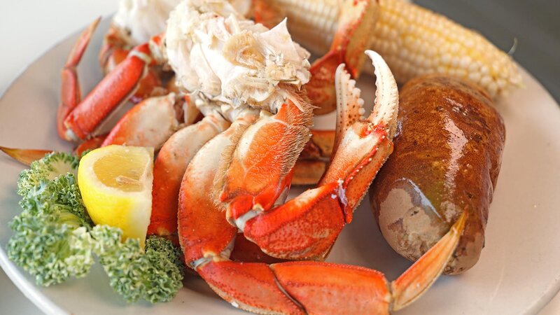 Crab claws with a side of potato, corn and lemon